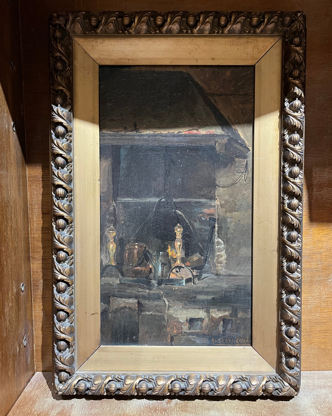 An 18th-century Italian oil painting depicting a hearth scene, with a wooden frame featuring acanthus leaf detailing.