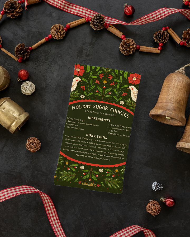 Holiday-themed recipe card for sugar cookies surrounded by decorative elements on a dark surface.