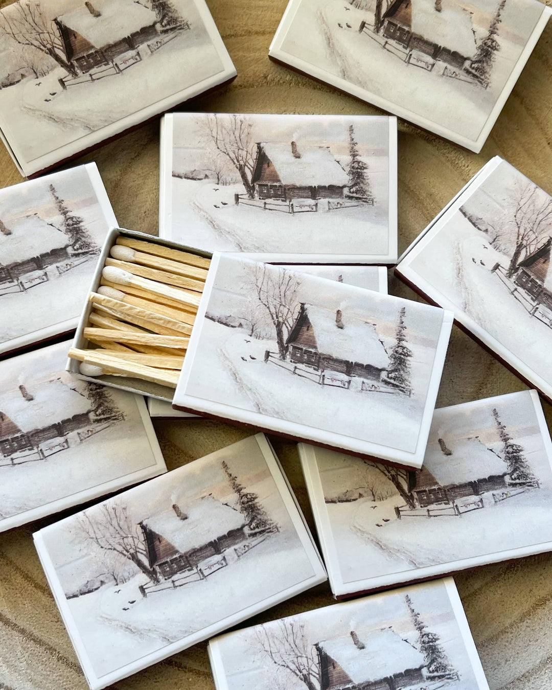 Matches in a decorative box with winter landscape design on a wooden surface