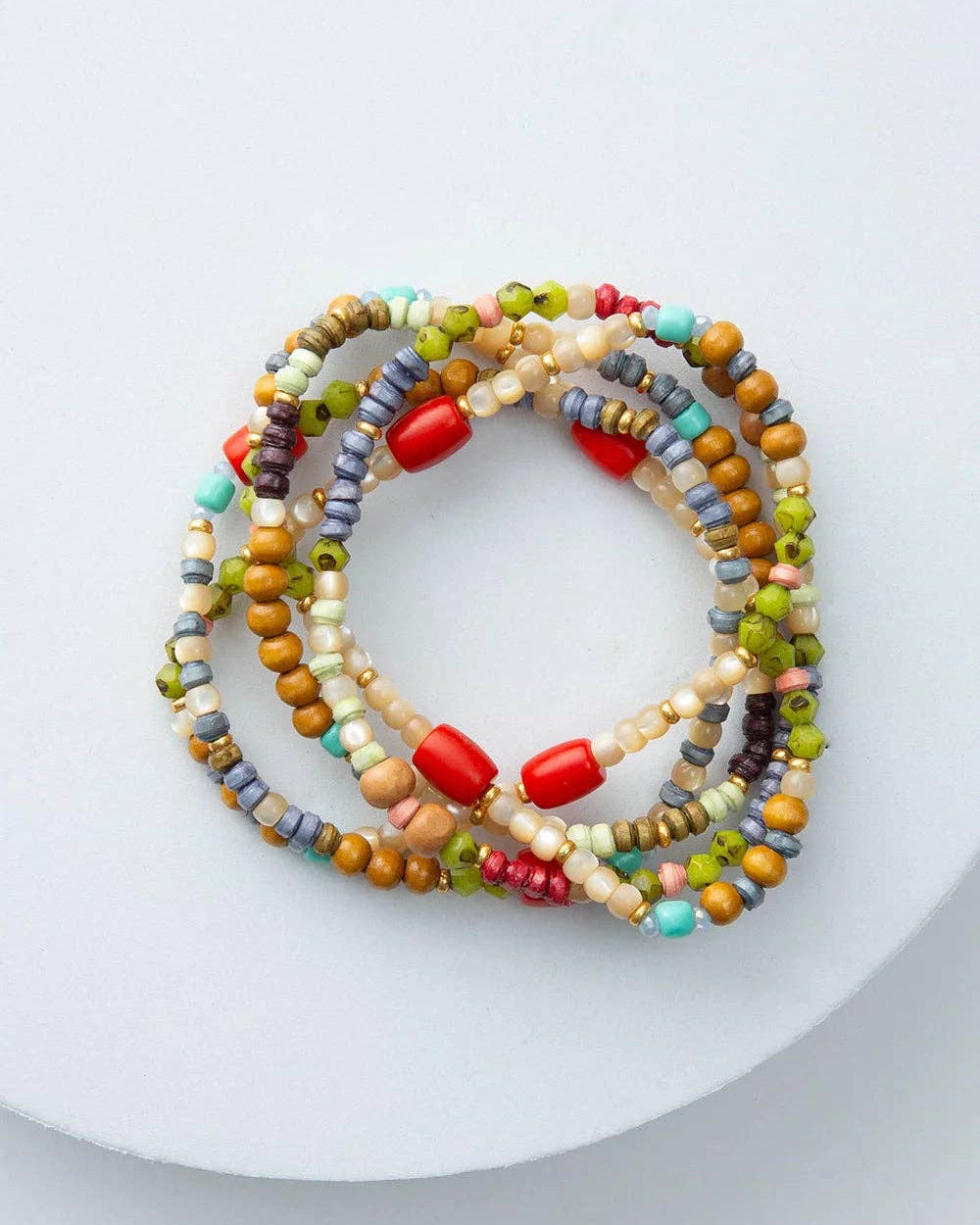 Set of colorful beaded bracelets on a white plate