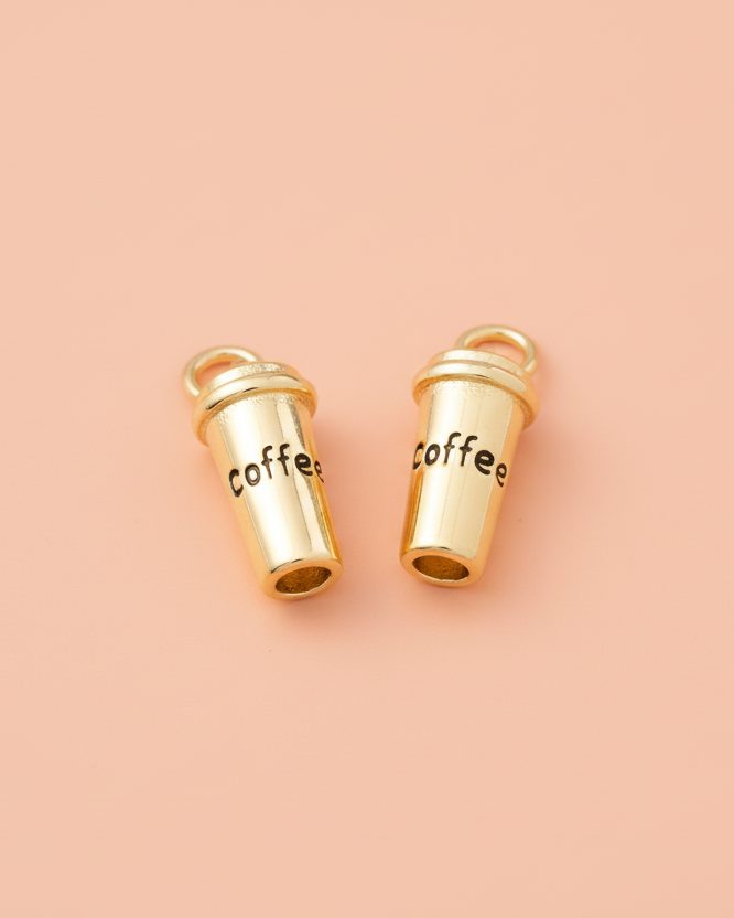 Two gold 'coffee' cup charms on a pink background