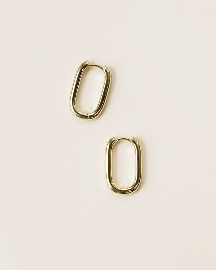 Pair of gold hoop earrings on a beige background