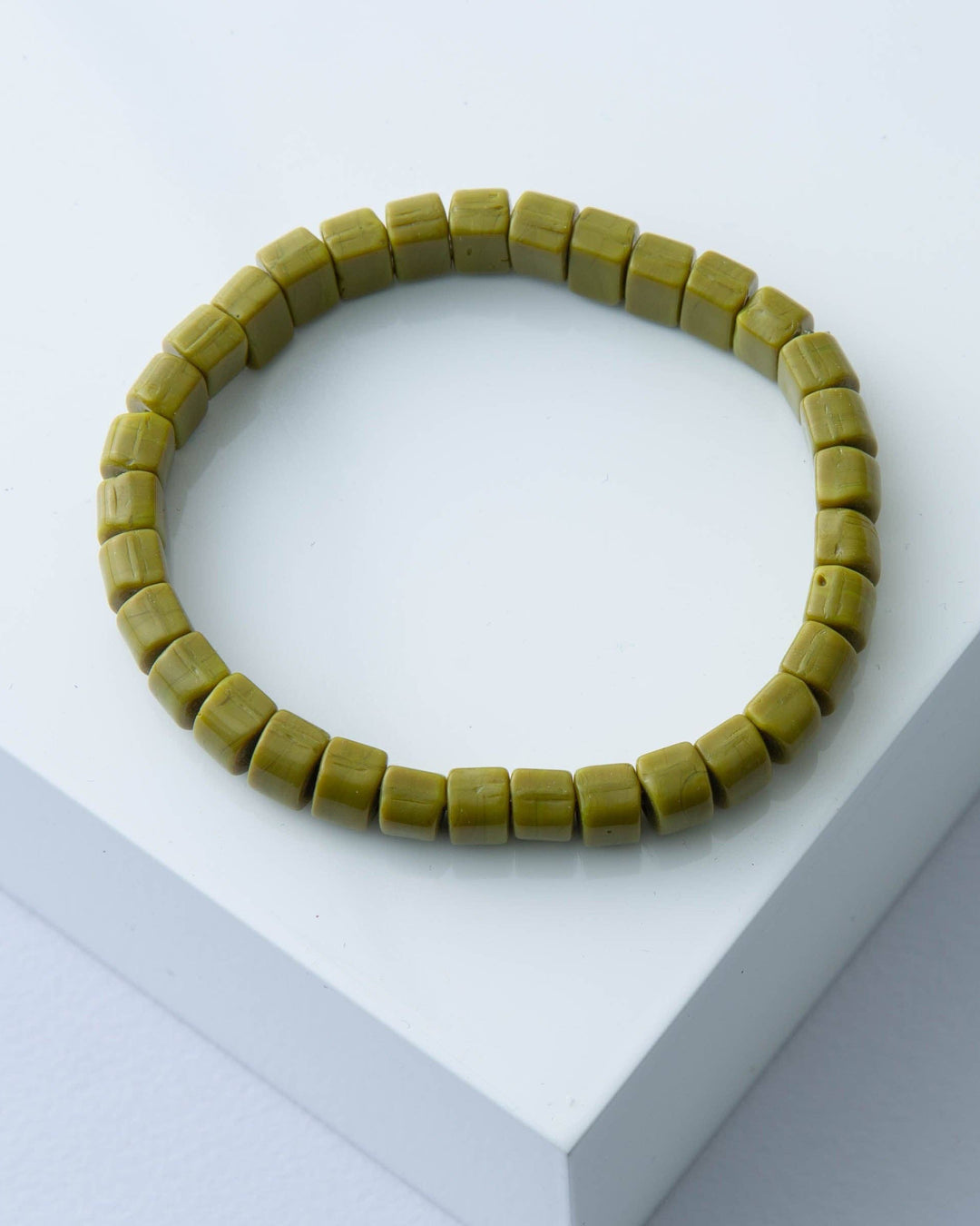 Green beaded bracelet on a white surface