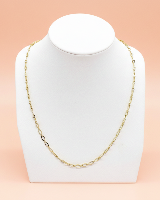 Gold chain necklace on a white stand with 'CB' logo on a peach background