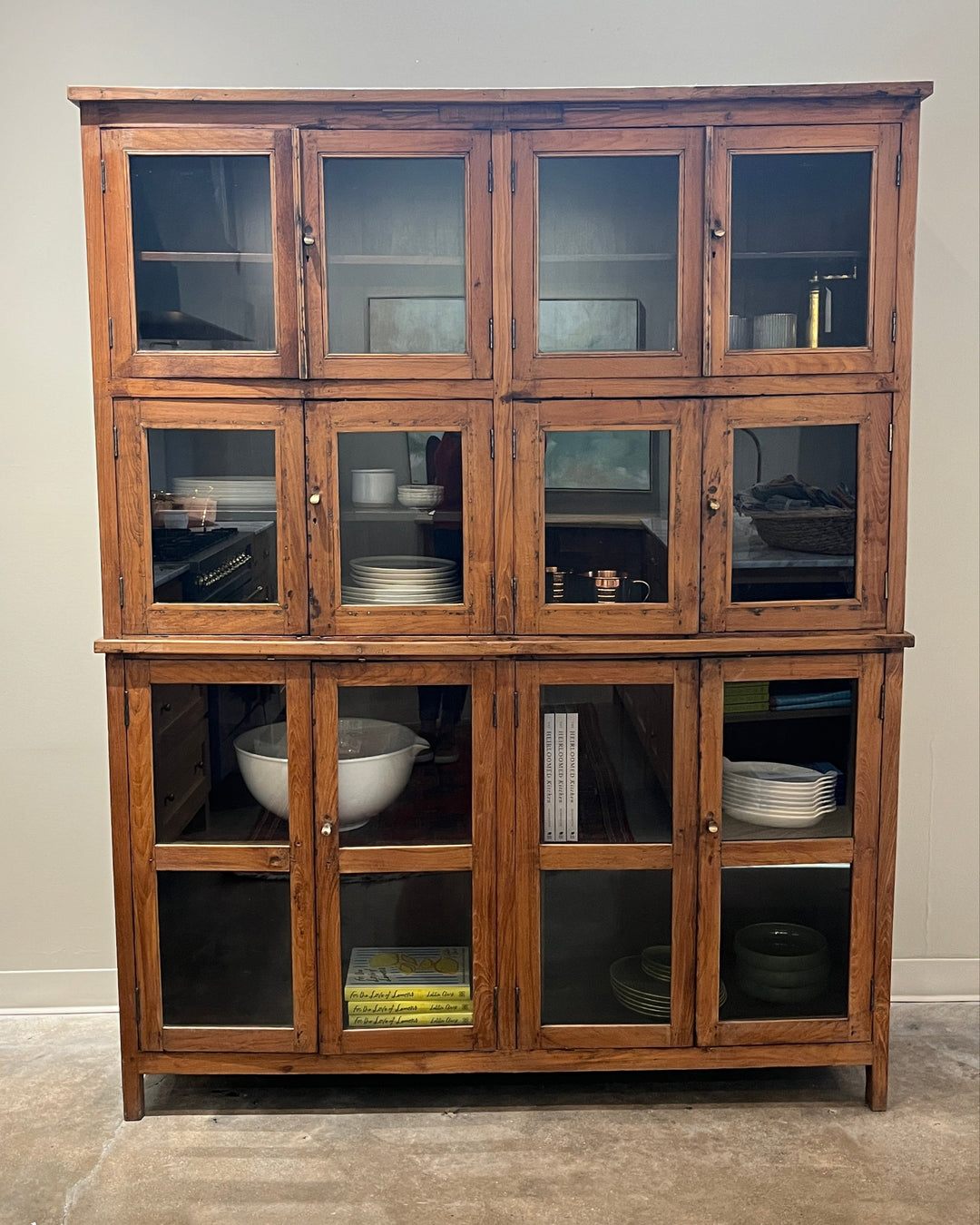 Wooden cabinet with glass doors against a wall