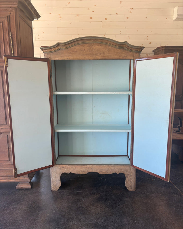 Wooden armoire with open doors in a room with wooden floor and wall.