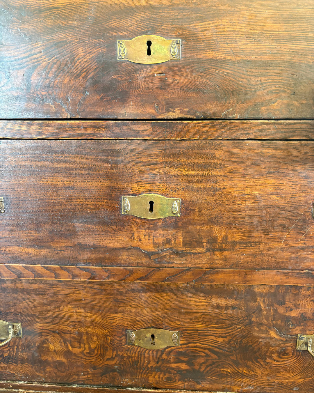 Close-up of a wooden chest with brass keyholes