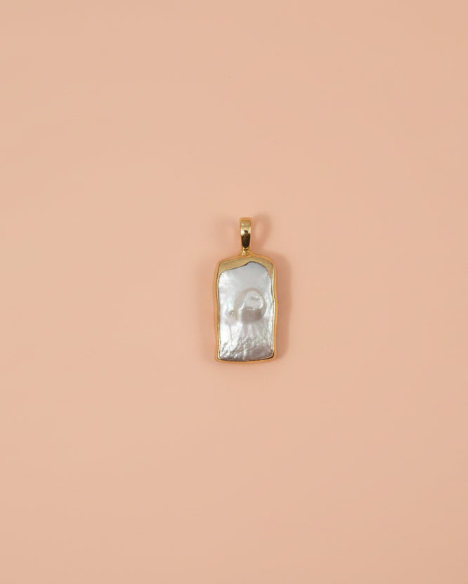 Small pendant with a textured surface on a beige fabric background
