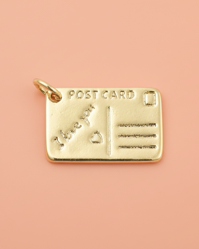 Gold postcard charm on a white background