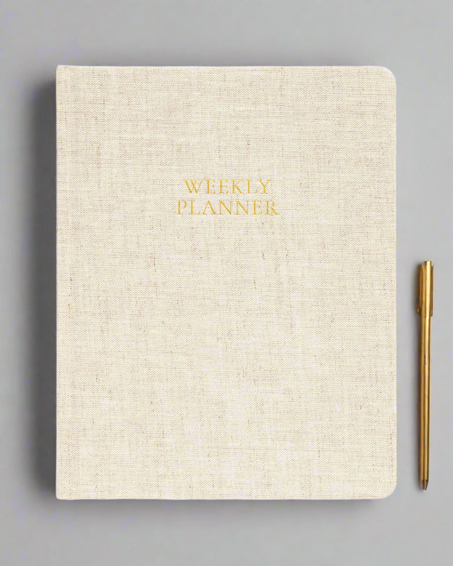 Beige planner with 'Weekly Planner' text in gold on a white background