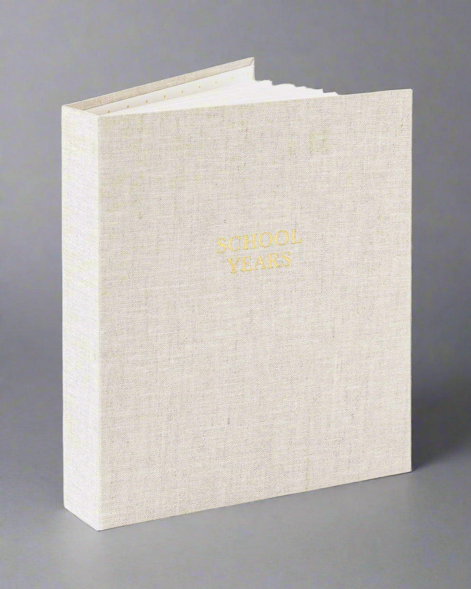 Beige photo album with gold text on a white background