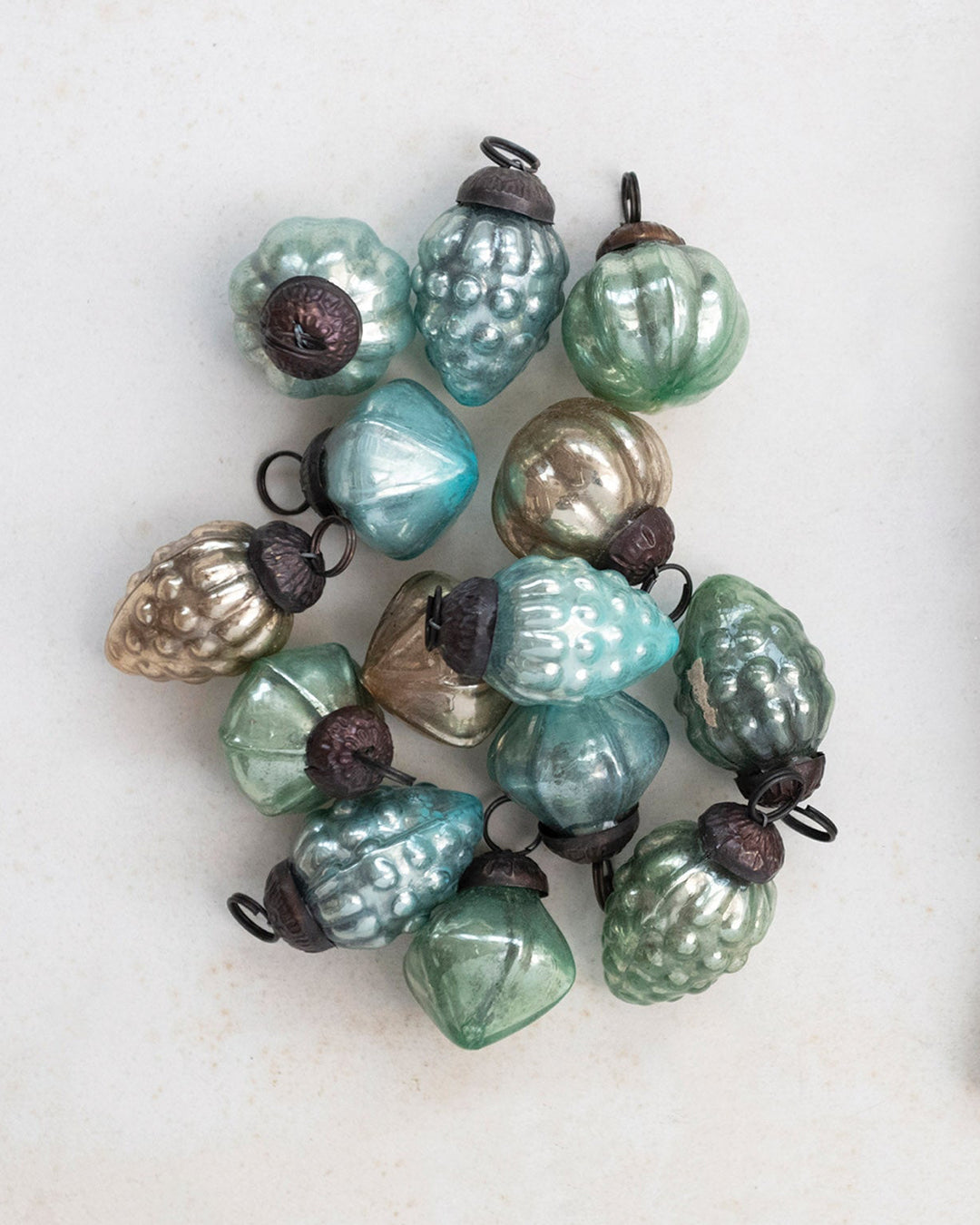 Decorative string of multicolored beads next to a drawstring bag on a light background