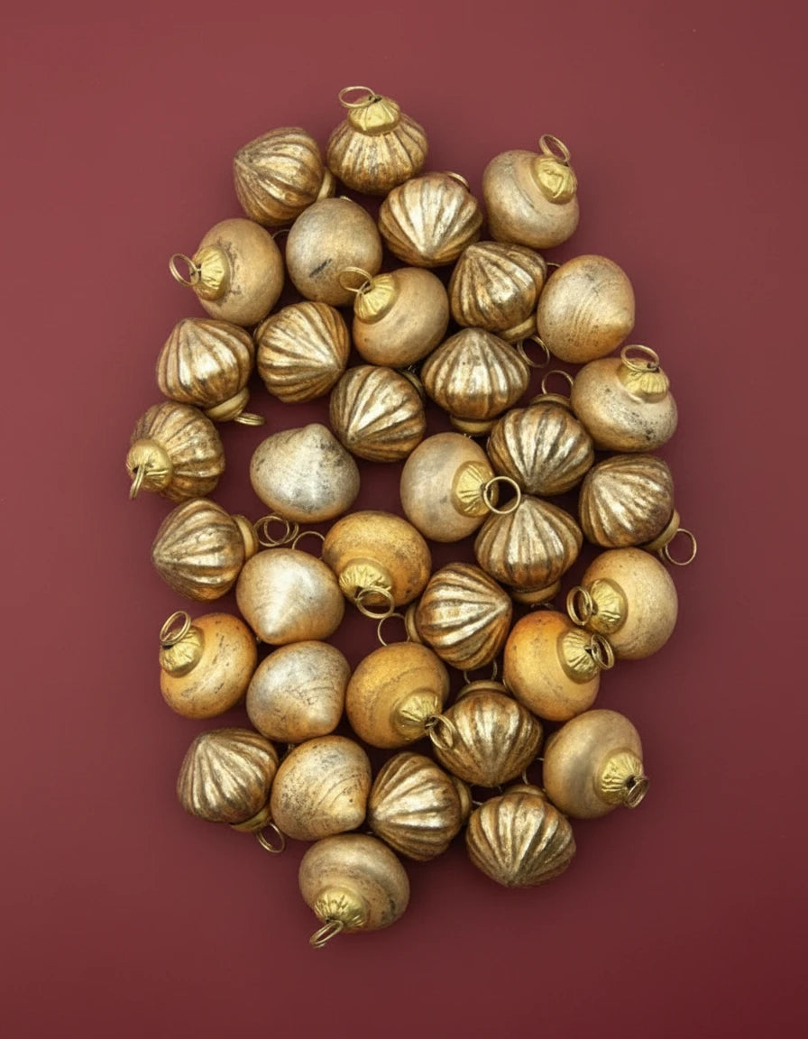 Gold decorative balls with a white drawstring bag on a white background